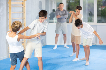 Sedulous underage practitioner of self-defense courses applying attack methods on his opponent