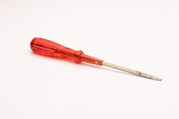 Fototapeta premium Red handled screwdriver with a metallic tip on a white background.