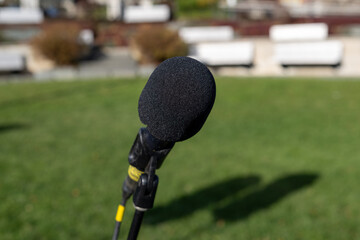 A black metal microphone on a stand. The round ball style mic is a classic for concerts and evening...