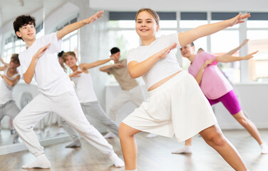 Fototapeta premium Group of boys and girls rehearsing hip hop dance in studio