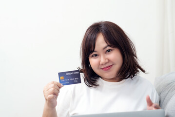 Teenage girl, smiling face, chubby body, shows credit card.