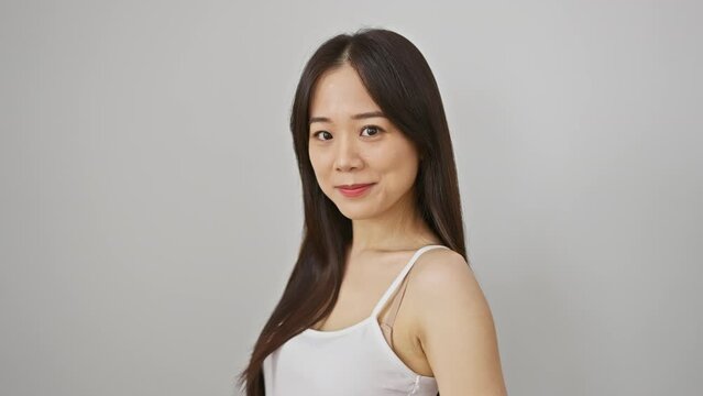 A portrait of a smiling young asian woman with long hair against a white background, exuding confidence and beauty.