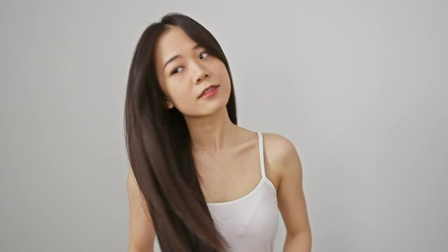 A young asian woman poses elegantly against a seamless white background, conveying natural beauty
