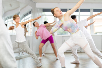 Group lesson in choreographic studio - teenagers learn to dance hip-hop and modern dances