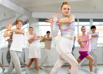 Group of teenagers learn to dance hip-hop and other modern dances in a spacious dance studio