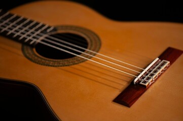 Fototapeta premium Classical Spanish flamenco guitar close up, dramatically lit isolated on black background with copy space.