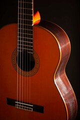 Fototapeta premium Classical Spanish flamenco guitar close up, dramatically lit isolated on black background with copy space.