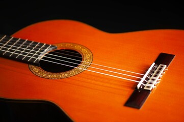 Classical Spanish flamenco guitar close up, dramatically lit isolated on black background with copy...
