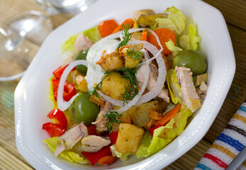 Delicious warm salad of chicken, eggplant, fried cheese with vegetables and cream sauce..