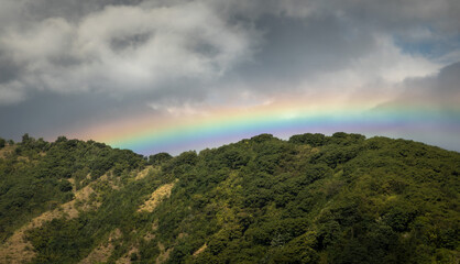 Rainbow over the green hills in rural Bali, Indonesia