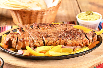 roast beef with seasonings and sliced ​​barbecue salad served on plate on wooden table