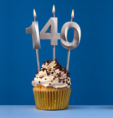 Burning candle number 140 - Birthday card with cupcake on blue Background