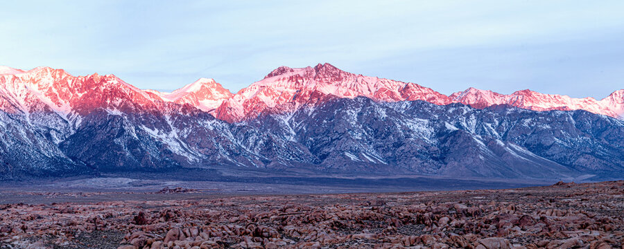 Sunrise moment at Mt Whitney with sunlight lightening the top of the mountains with snow