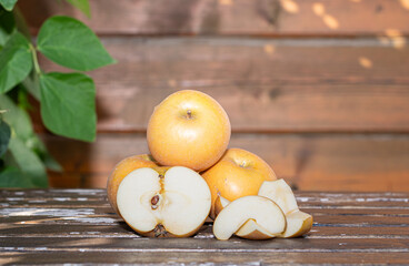 Crisp freshly picked local apples rustic brown Russetts cut open to expose white flesh on a table outside with warm sunlight