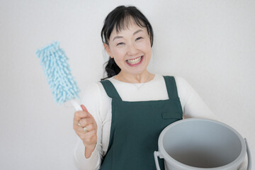 掃除道具と笑顔の中高年女性