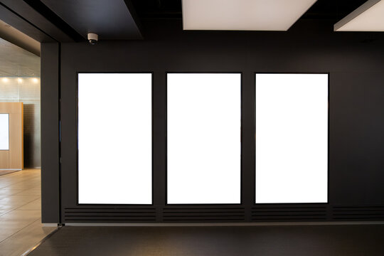 Triple Vertical digital Poster Mockup background in Sleek Modern Interior. Blank white showcase screen on a wall inside an urban building. Empty 
 advertisement display media panels for promotion.