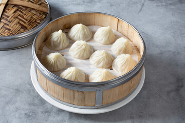 A view of several xiaolongbao dumplings in a bamboo steamer basket.