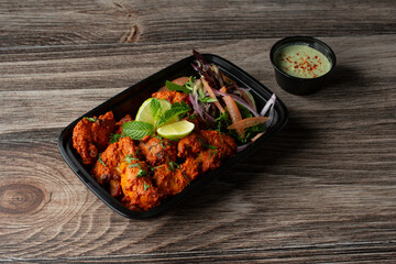 A view of a container of chicken tikka.