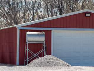 Gravity flow fuel tank on stand on the side of a barn.
