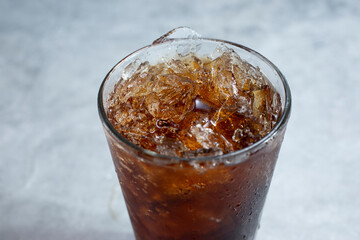 A closeup view of an ice cold cola soda in a glass.