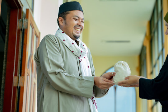 Ramadan, Zakat, Muslim Hands are holding a wooden bowl of rice grains for zakat, an Islamic zakat concept. Muslims to help the poor and needy. Conceptual shoot for property, income, and fitrah zakat.