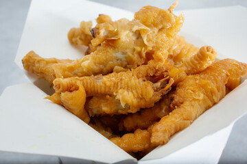 A view of a take out container of chicken feet.