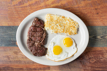 A top down view of a plate of steak and eggs.