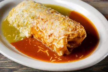 Fototapeten A closeup view of a red and green wet burrito. © DAVID