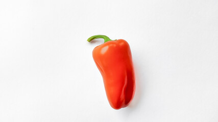 Bright red bell pepper on a white background with copy space, ideal for healthy food concepts and vegetarian cuisine advertisements