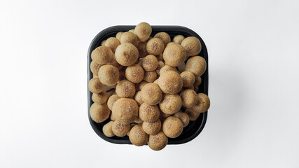 Top view of fresh brown shimeji mushrooms in a black tray isolated on white background, with space for text, ideal for food and culinary concepts