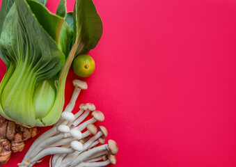 Vibrant food background with fresh bok choy, enoki mushrooms, and a lime on a vivid pink backdrop with copy space, ideal for healthy lifestyle and culinary concepts - obrazy, fototapety, plakaty