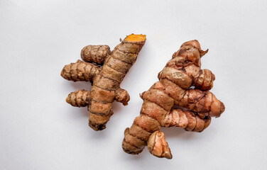 Fresh turmeric roots on a clean white background with space for text, ideal for food and health-themed designs or culinary articles
