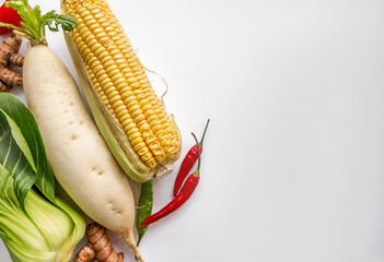 Assorted fresh vegetables including corn, red chili, and bok choy with copy space on white background, ideal for healthy eating and vegetarian concepts - obrazy, fototapety, plakaty