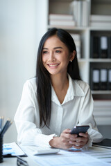 Obraz premium Accountant, Asian independent business woman Positive concept using smartphone to relax with mobile app and use chat business communication Contact online marketing that is extremely profitable.