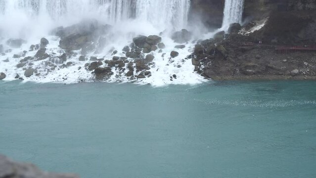 A massive flock of birds congregating behind a majestic waterfall