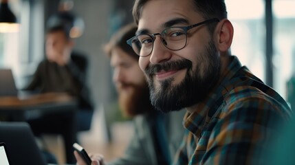 cheerful businessman in eyeglasses typing on laptop while sitting near colleague with mobile phone and bearded man on blurred foreground in lounge of modern coworking space : Generative AI