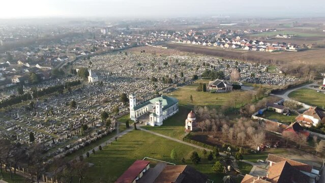 Drone flight above the Catholic church and cemetery on the sunrise. Sombor, Serbia, Europe. 4k.