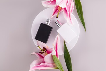Black and white matte bottles of perfume with a natural smell of freshness lie on a white round...