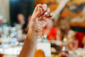 Female hand with crystal bell with gold decor.