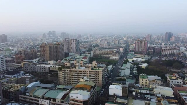 A dense cityscape at dawn with buildings stretching to the horizon, aerial view