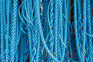 background close up of industrial blue ropes hanging vertically