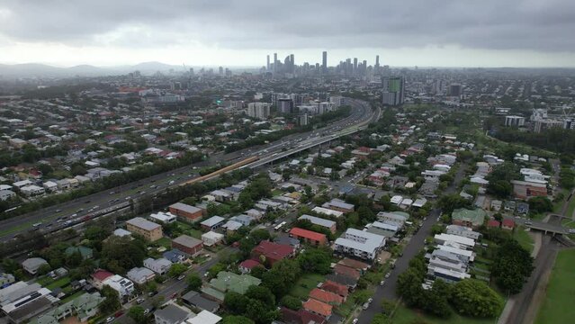 Aerial View Of Suburb And Brisbane Skyline With Overcast In Queensland, Australia. sideways shot