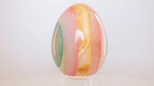 layered mineral egg, likely made from Agate or Quarts. Rotating on a turn table in front of a white background.
