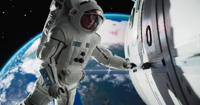 Astronaut on an Extravehicular Mission in Outer Space. Courageous Man Holding by the Handle, Inspecting the Space Station During a Service Procedure. Planet Earth Rotating in the Background