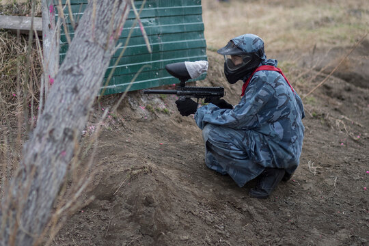 Paintball. Gun and soldier with a sports man playing a military game for fun or training outdoor. War, camouflage and target with a male athlete shooting a weapon outside during an army exercise