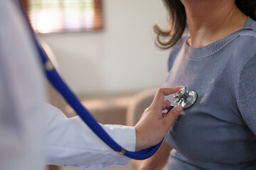 A doctor is checking a woman's heart