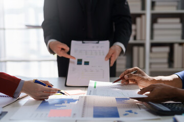 Business team analyzing financial data and charts during a meeting. Corporate finance and strategy planning concept.