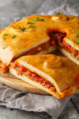 Spanish Empanada Gallega Galician Pork and Pepper Pie closeup on the board on the table. Vertical