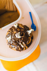chocolate cake on highchair with blue spoon