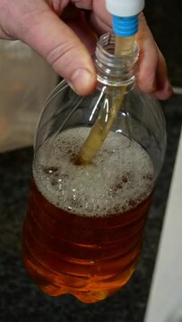 Pouring beer into a bottle close-up